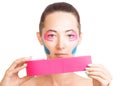 Woman with facelift taping holding roll of kinesiology tape.