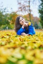 Young woman on a fall day, laying on the ground with colorful autumn leaves Royalty Free Stock Photo