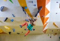 Young woman falling down while bouldering in climbing gym