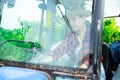 Young woman farm worker driving small tractor in orchard Royalty Free Stock Photo