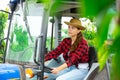 Young woman farm worker driving small tractor in orchard Royalty Free Stock Photo