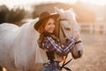 A woman stroking a horse at a ranch.