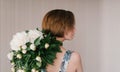 Young woman in fashon dress holding bouquet of beautiful white peonies flowers behind her back St. Valentine`s Day, International Royalty Free Stock Photo