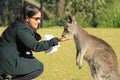 Woman feeding grass to congaroo