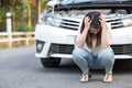 Young asian woman feel sad sitting near the broken down car