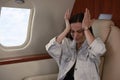 Young woman feeling bad during flight in airplane