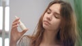 Young woman feeling blocked nose while allergy and spraying nasal spray