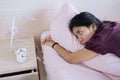 Young woman lying on the bed with alarm clock Royalty Free Stock Photo