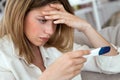 Young woman feeling depressed and sad after looking at pregnancy test result at home. Royalty Free Stock Photo