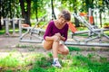 Young woman feeling pain in her knee during sport workout in the Royalty Free Stock Photo