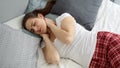 Young woman feeling pain in neck and massaging muscles after sleeping on uncomfortable bed Royalty Free Stock Photo