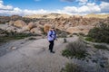Young woman female hiker wearing a backpack starts off on a hiking trail in Joshua Tree National Park, to the Arch Rock Royalty Free Stock Photo