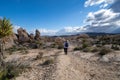 Young woman female hiker wearing a backpack starts off on a hiking trail in Joshua Tree National Park, to the Arch Rock Royalty Free Stock Photo