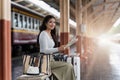 Young woman female traveler looking on map while waiting for the train at train station Royalty Free Stock Photo