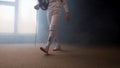 A young woman fencer walking to the fighting area - smoky studio