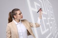 Young woman finding the maze solution, writing on whiteboard. Royalty Free Stock Photo