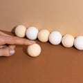 Young woman fingers touch the organic bath bombs with shadow on beige background. Spa concept. Presents for body Royalty Free Stock Photo