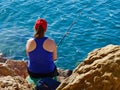 Young woman fishing by the ocean