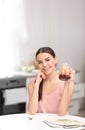 Young woman in fitness clothes having breakfast at home