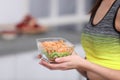 Young woman in fitness clothes holding bowl of cereal breakfast with fruits at home Royalty Free Stock Photo