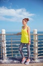 Young woman in fitness outfit looking aside at embankment Royalty Free Stock Photo