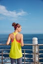 Young woman in fitness outfit looking aside at embankment Royalty Free Stock Photo