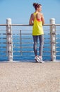 Young woman in fitness outfit looking aside at embankment Royalty Free Stock Photo