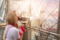 A young woman with the flag of Austria in her hands looks through observation binoculars and enjoys the panorama of the Royalty Free Stock Photo