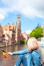 A young woman with the flag of Belgium in her hands is enjoying the view of the canals in the historical center of Royalty Free Stock Photo