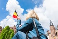 A young woman with the flag of Belgium in her hands is enjoying the view of the canals in the historical center of Royalty Free Stock Photo