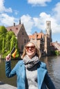 A young woman with the flag of Belgium in her hands is enjoying the view of the canals in the historical center of Royalty Free Stock Photo