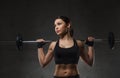 Young woman flexing muscles with barbell in gym Royalty Free Stock Photo