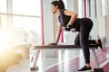 Woman flexing muscles with dumbbell on bench in gym Royalty Free Stock Photo