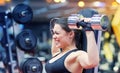 Young woman flexing muscles with dumbbell in gym Royalty Free Stock Photo