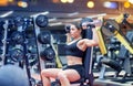 Young woman flexing muscles with dumbbell in gym Royalty Free Stock Photo