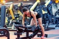 Young woman flexing muscles with dumbbell in gym Royalty Free Stock Photo