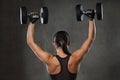 Young woman flexing muscles with dumbbells in gym Royalty Free Stock Photo