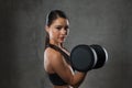 Young woman flexing muscles with dumbbells in gym Royalty Free Stock Photo