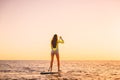 Young woman floating at stand up paddle board with warm sunset colors Royalty Free Stock Photo