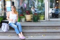 Young woman on the floor on the street looking in camera using p Royalty Free Stock Photo