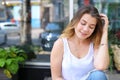 Young woman on the floor on the street looking in camera using p Royalty Free Stock Photo