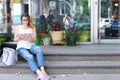 Young woman on the floor on the street looking in camera using p Royalty Free Stock Photo