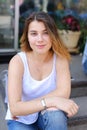 Young woman on the floor on the street looking in camera using p Royalty Free Stock Photo