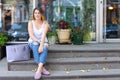 Young woman on the floor on the street looking in camera using p Royalty Free Stock Photo