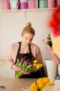 Woman makes a bouquet of tulips in floral shop