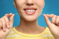 Young woman flossing her teeth on blue background, closeup. Cosmetic dentistry Royalty Free Stock Photo