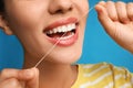 Young woman flossing her teeth on blue background, closeup. Cosmetic dentistry Royalty Free Stock Photo