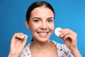 Young woman flossing her teeth on blue background. Cosmetic dentistry Royalty Free Stock Photo