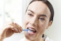 Young Woman Flossing Teeth In Bathroom Royalty Free Stock Photo