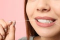 Young woman flossing teeth on color background Royalty Free Stock Photo